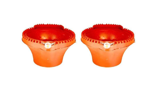 Two red ceramic pots with small white lights inside on a white background