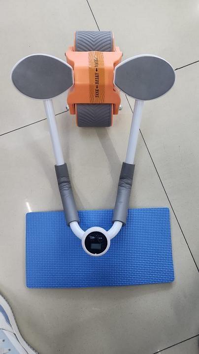 Fitness equipment with handles and a blue mat on a tiled floor
