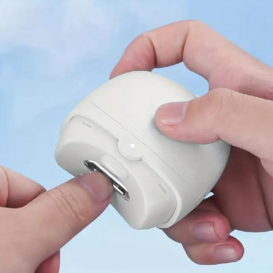 Hand holding a white electronic device with a USB port against a light blue background