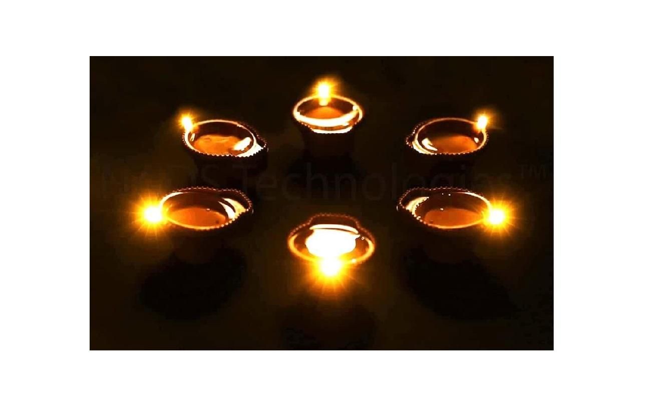 Small candles in oil lamps on a dark background