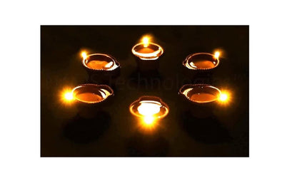 Small candles in oil lamps on a dark background
