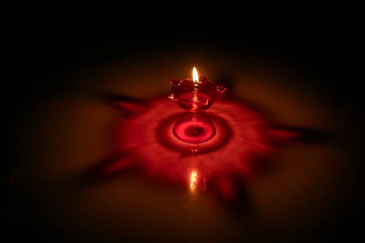Red candle in water with a dark background