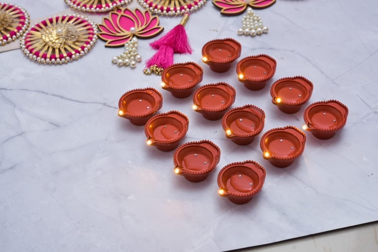 Decorative oil lamps (diyas) on a white surface with decorative elements.