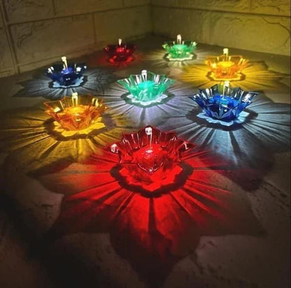 Colorful glass bowls with candles on a textured surface