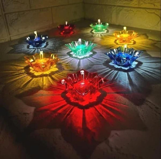 Colorful glass bowls with candles on a textured surface